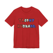 Red t-shirt with 'Trophy Husband' in red white and blue text on a white background
