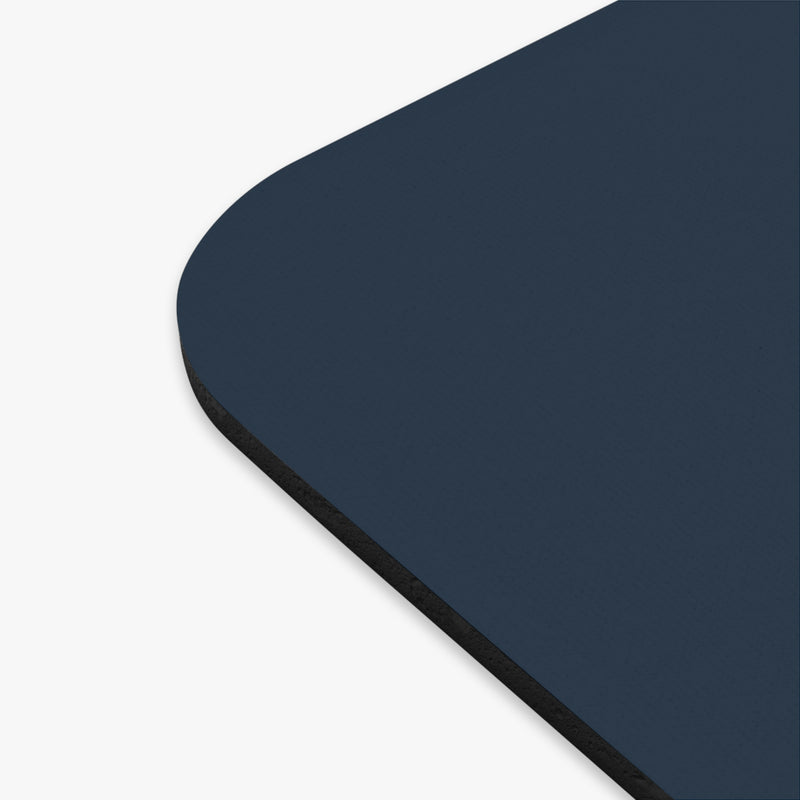 The edge of a navy blue mouse pad with a circular design featuring an eagle and text celebrating America's 250th anniversary.