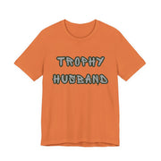 Orange t-shirt with 'Trophy Husband' text on a white background