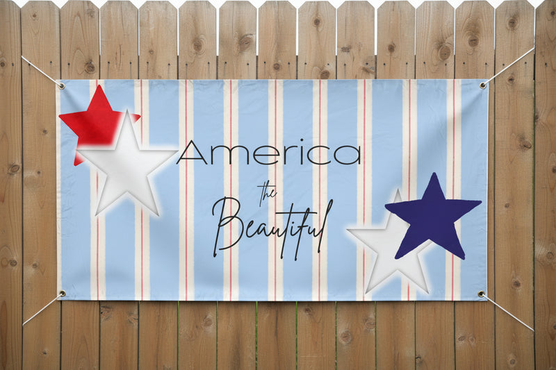 Patriotic “America the Beautiful” vinyl banner with blue stripes and red and blue stars, 72x36 and 48x24 inches hanging on fence.
