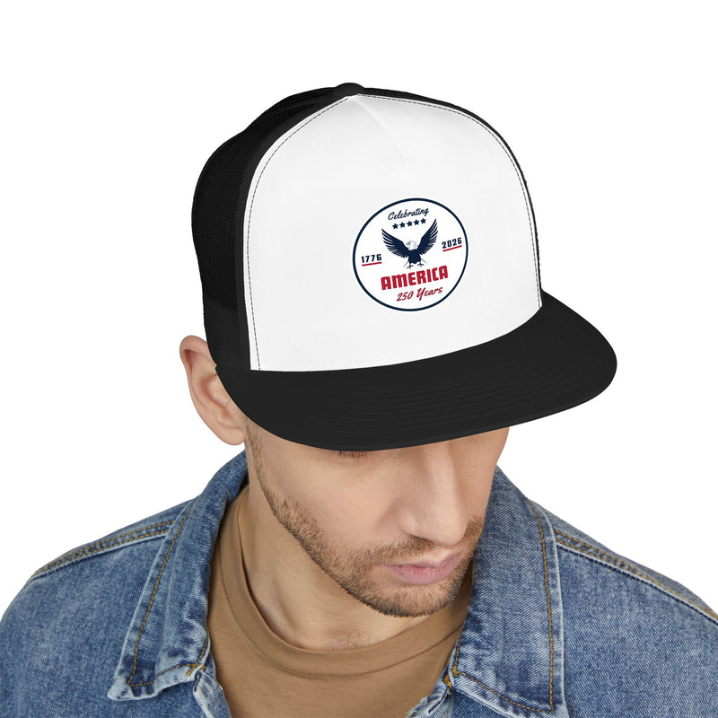 Man wearing a white and black flat bill trucker cap with a logo 'celebrating America 250 years' on a white background.