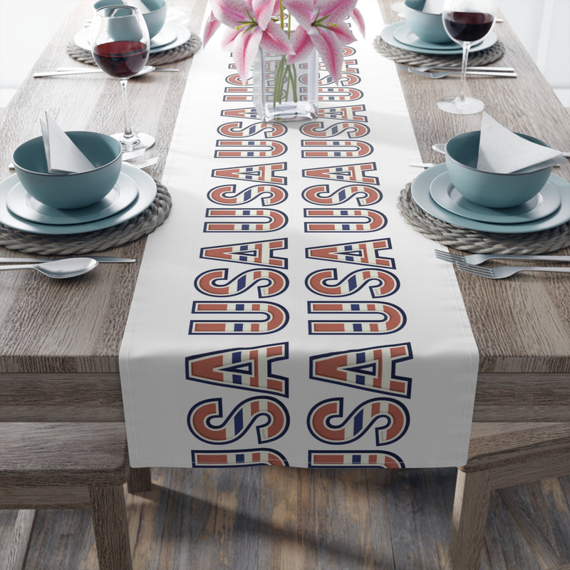 USA themed table runner displayed from the head of the table with plates, and glasses.