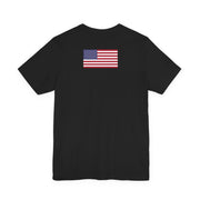 Back of a black t-shirt with American flag on the back against a white background