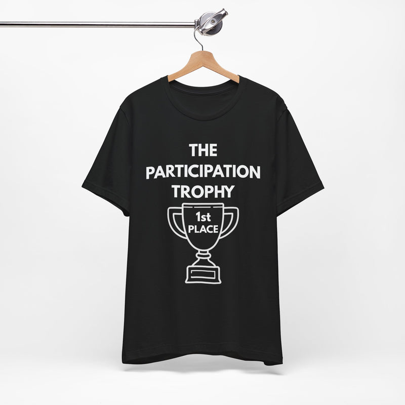 Black t-shirt with white text and white graphic on a hanger saying 'The Participation Trophy - 1st Place'