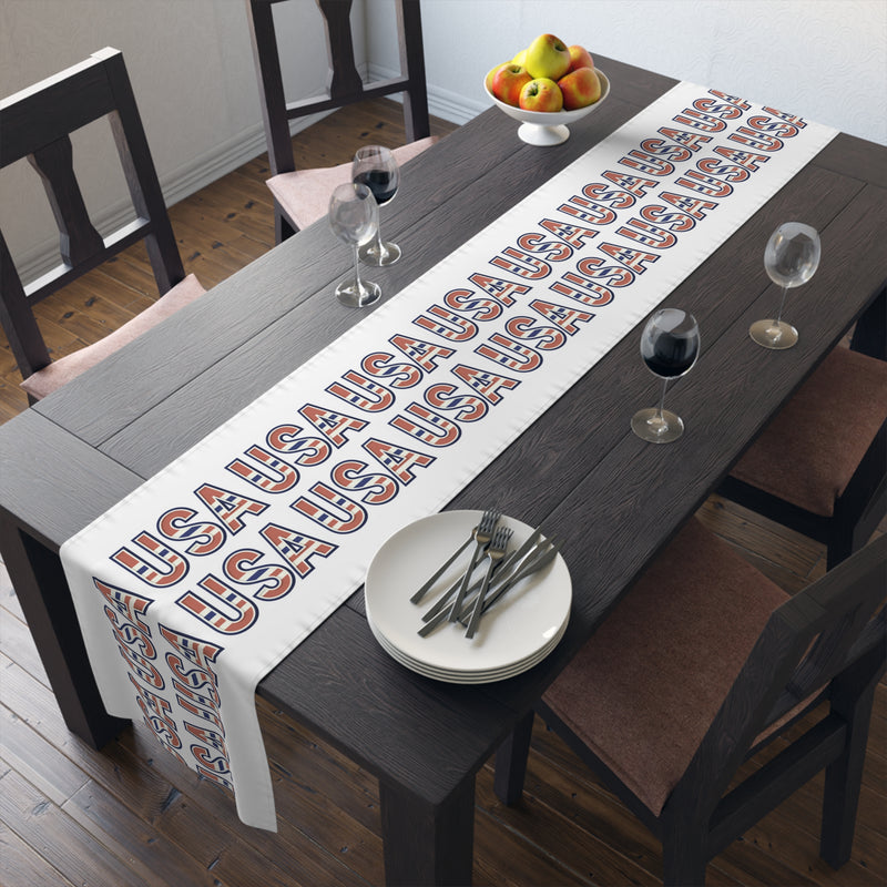 USA themed table runner on a dining room table with plates, and glasses.