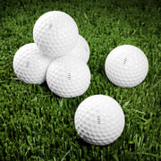 Customizable white multiple golf balls with a "your design or words" placeholder on grass.