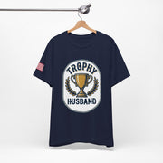 Navy blue t-shirt with 'Trophy Husband' graphic on a hanger against a white background