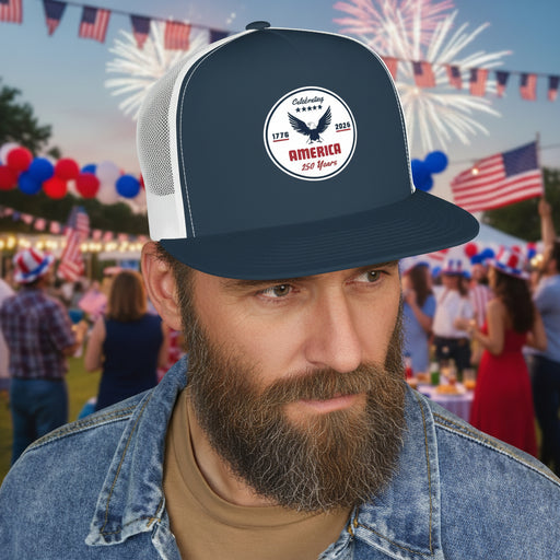 Man wearing a navy blue and white flat bill trucker cap with a logo 'celebrating America 250 years' displayed in front of a party. 