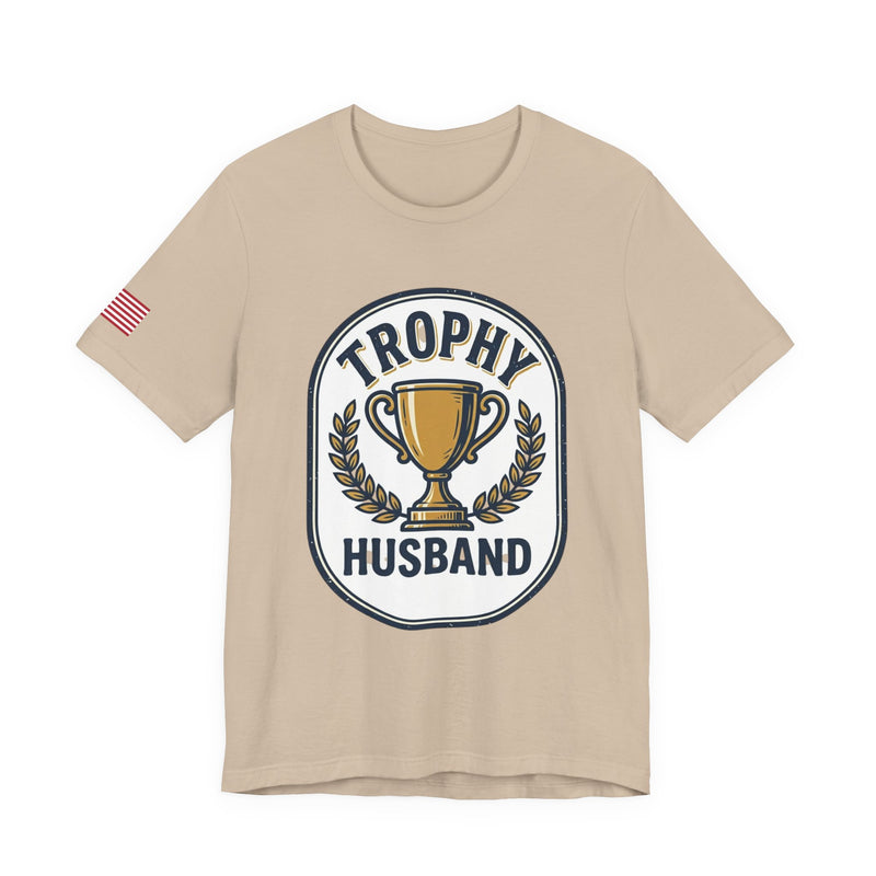 Beige t-shirt with 'Trophy Husband' graphic on a white background