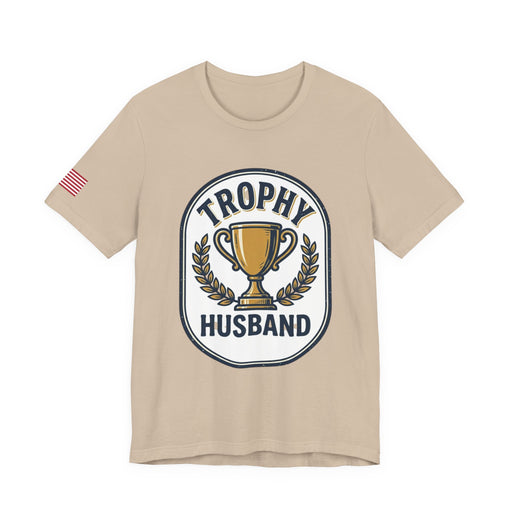 Beige t-shirt with 'Trophy Husband' graphic on a white background