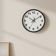 Customizable wall clock with black frame with a "your image" placeholder on an indoor wall.