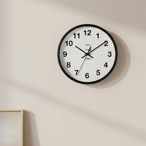 Customizable wall clock with black frame with a "your image" placeholder on an indoor wall.