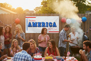Patriotic “God Bless America” horizontal vinyl banner with blue stripes and red and blue stars hanging above a party table on wood fence, 48x24 and 72x36 inches.