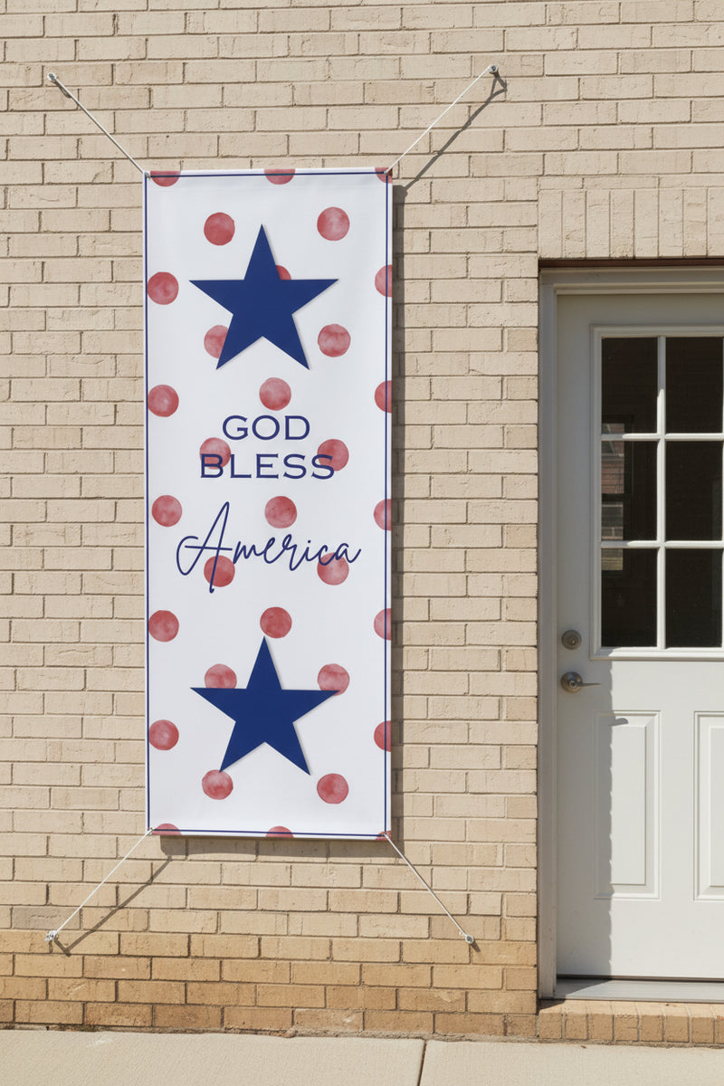 Patriotic “God Bless America” vertical matte banner with red polka dot background hanging on back of house, 36x96 inches.