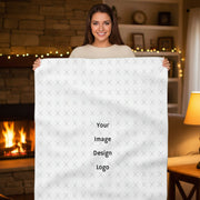 Customizable sherpa fleece blanket with "your image or design" placeholder displayed by a woman in a cozy house.