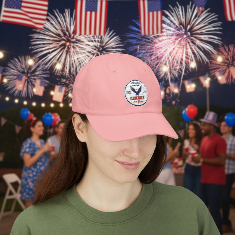 Girl wearing all pink classic ball cap with a circular emblem featuring an eagle and text , along with the American flag on the side in front of a party. 