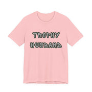Pink t-shirt with 'Trophy Husband' text on a white background