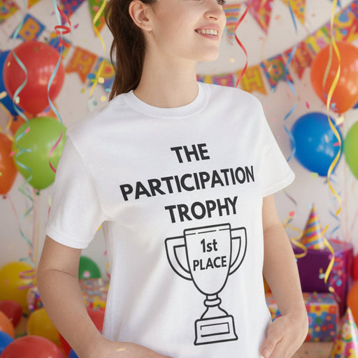 Female wearing a white t-shirt with 'The Participation Trophy' design, standing at a kids party.