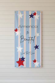 Vertical patriotic matte banner 24x48 and 36x72 inches with strips and red white and blue stars on a shiplap wall.

