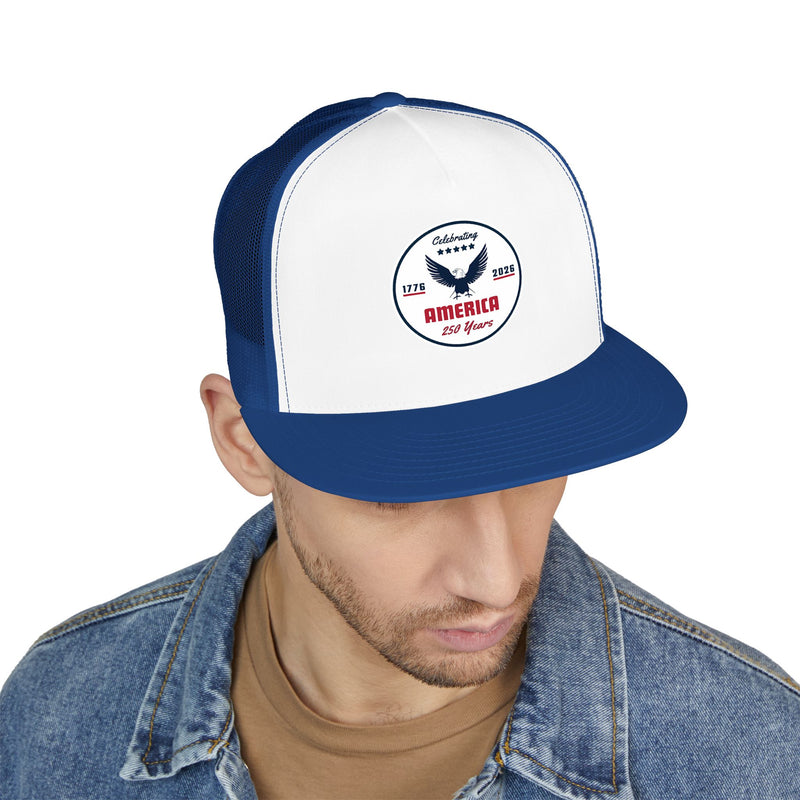 Man wearing a light blue and white flat bill trucker cap with a logo 'celebrating America 250 years' on a white background.