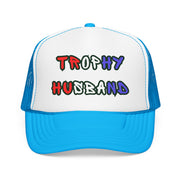 Bright blue Trucker hat with 'Trophy Husband' in red white and blue text, standing against a white background