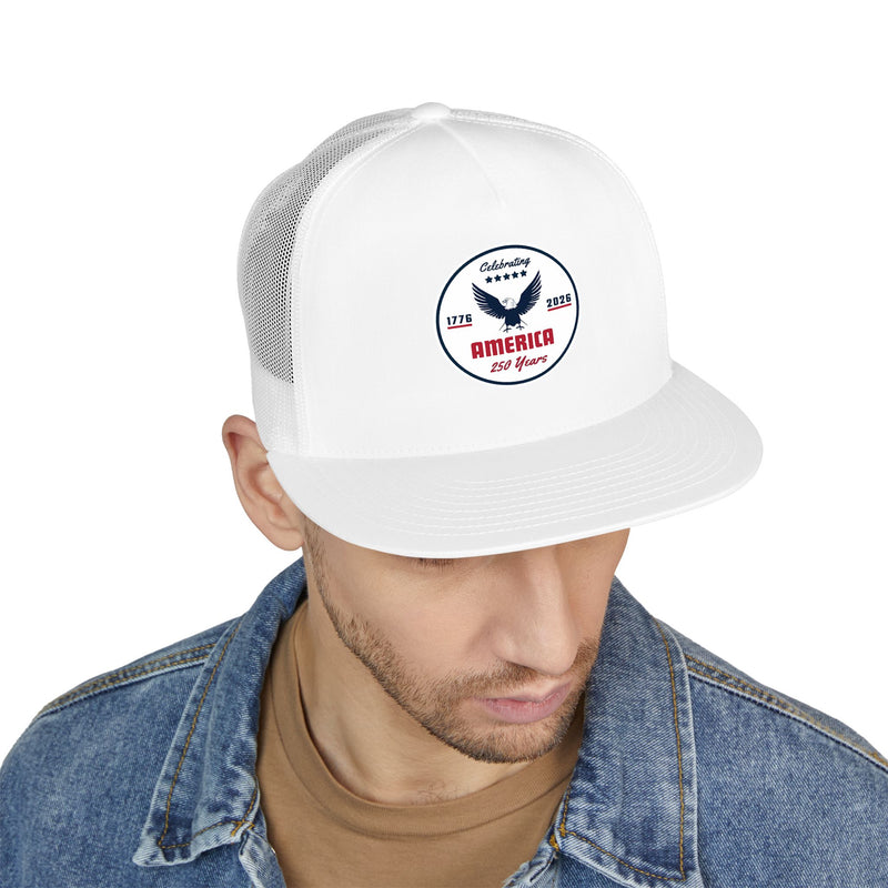 Man wearing an all white flat bill trucker cap with a logo 'celebrating America 250 years' on a white background.