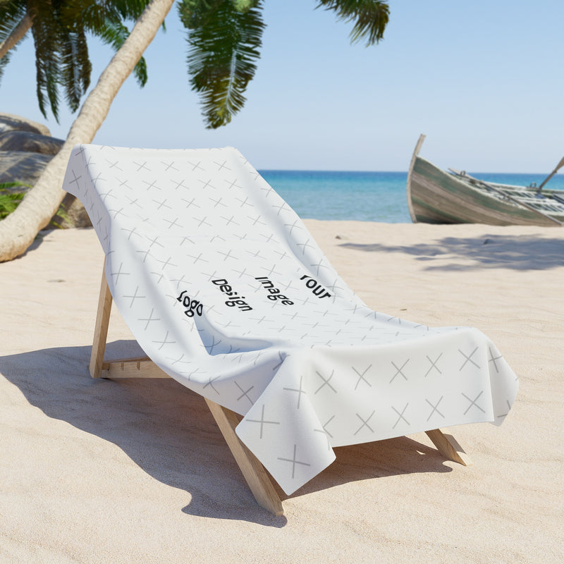 Customizable white beach towel with "your image or design" placeholder on a chair at the beach.