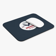 Navy blue mouse pad with a circular design featuring an eagle and text celebrating America's 250th anniversary with a white computer mouse.