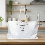 Customizable white weekender tote bag with "your image or design" placeholder sitting on a kitchen counter.
