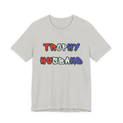 Gray t-shirt with 'Trophy Husband' in red white and blue text on a white background