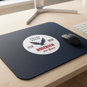 Navy blue mouse pad with a circular design featuring an eagle and text celebrating America's 250th anniversary on a desk.