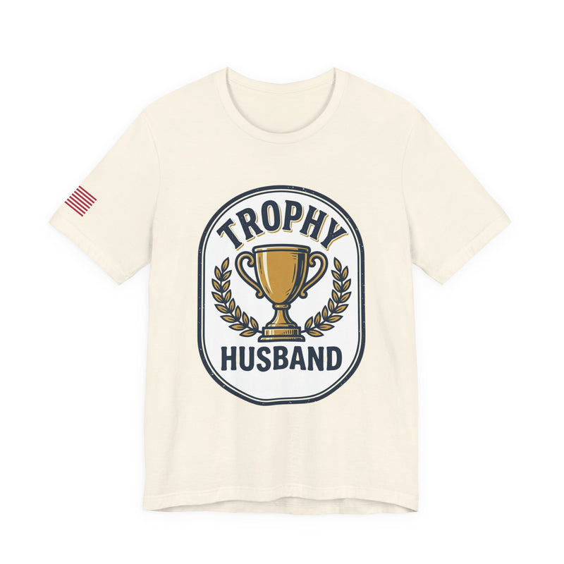 Natural color t-shirt with 'Trophy Husband' graphic design on a white background