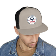 Man wearing a stone color front and black back flat bill trucker cap with a logo 'celebrating America 250 years' on a white background.