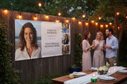 Custom vinyl photo banner with large portrait, three smaller photos, and space for name and special message hanging above a party table on wood fence, 72x36 and 48x24 inches.