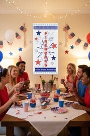 Patriotic vertical matte banner with red white and blue stars, fireworks and the word fireworks 24x48 and 36x72 inches displayed indoors above a table with people. 
