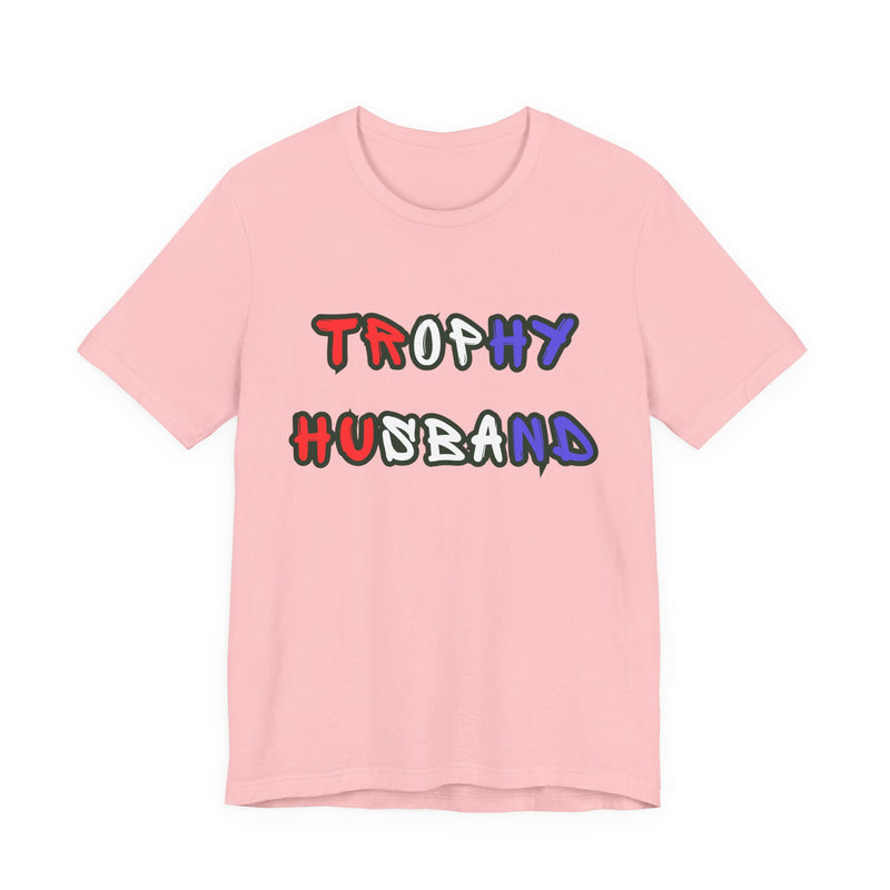 Pink t-shirt with 'Trophy Husband' in red white and blue text on a white background