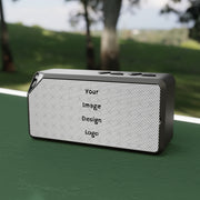 Customizable black Bluetooth speaker on a table at the park.