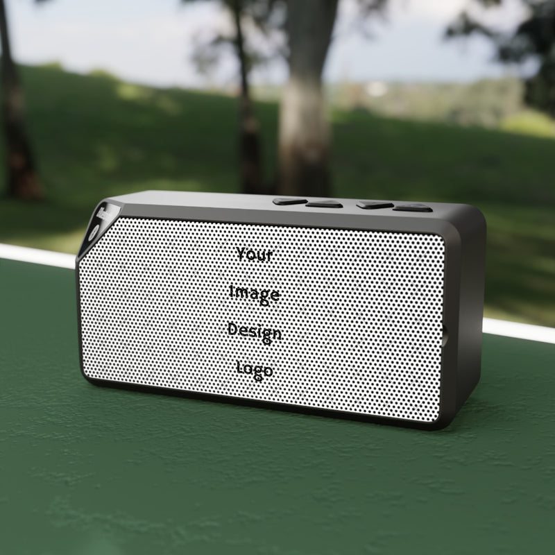 Customizable black Bluetooth speaker on a table at the park.