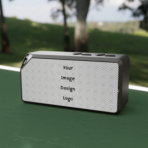 Customizable black Bluetooth speaker on a table at the park.