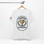 White t-shirt with 'Trophy Husband' graphic on a hanger against a white background