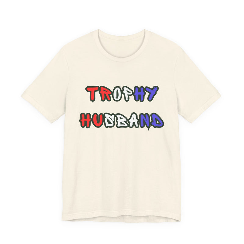 Beige t-shirt with 'Trophy Husband' in red white and blue text on a white background