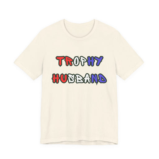 Beige t-shirt with 'Trophy Husband' in red white and blue text on a white background