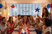 Patriotic “America the Beautiful” matte banner with blue stripes and red and blue stars hanging above a party table, 96x36 inches