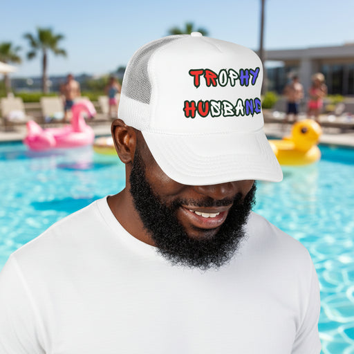 Man wearing a white cap with 'Trophy Husband' in red white and blue text, standing in front of a pool party.