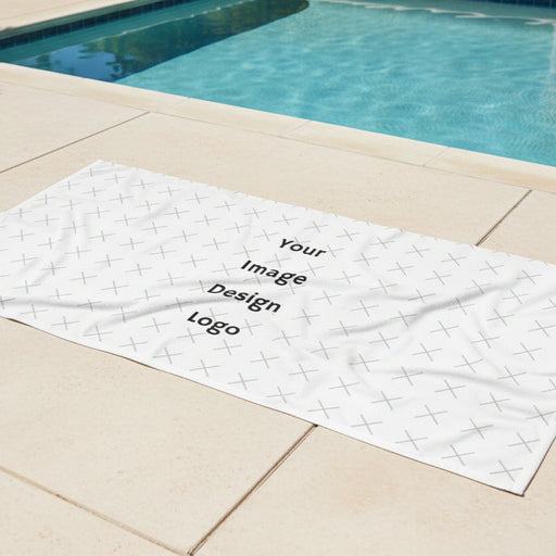 Customizable white beach towel with "your image or design" placeholder on a pool deck next to a pool. 